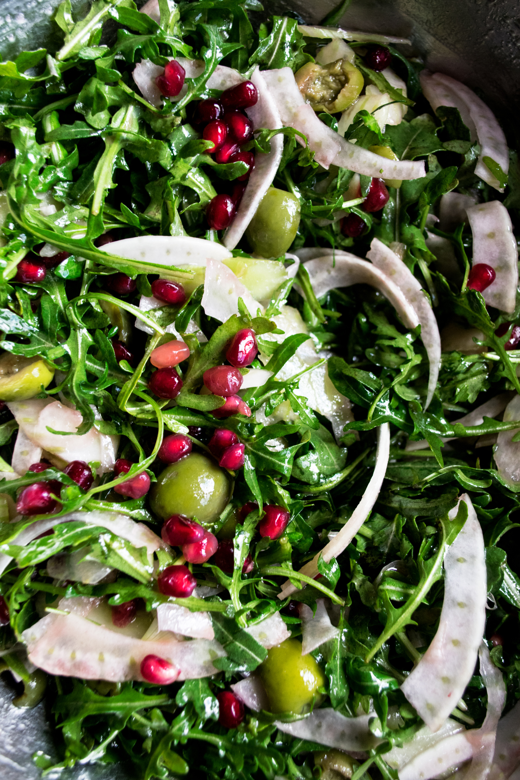 arugula salad being tossed