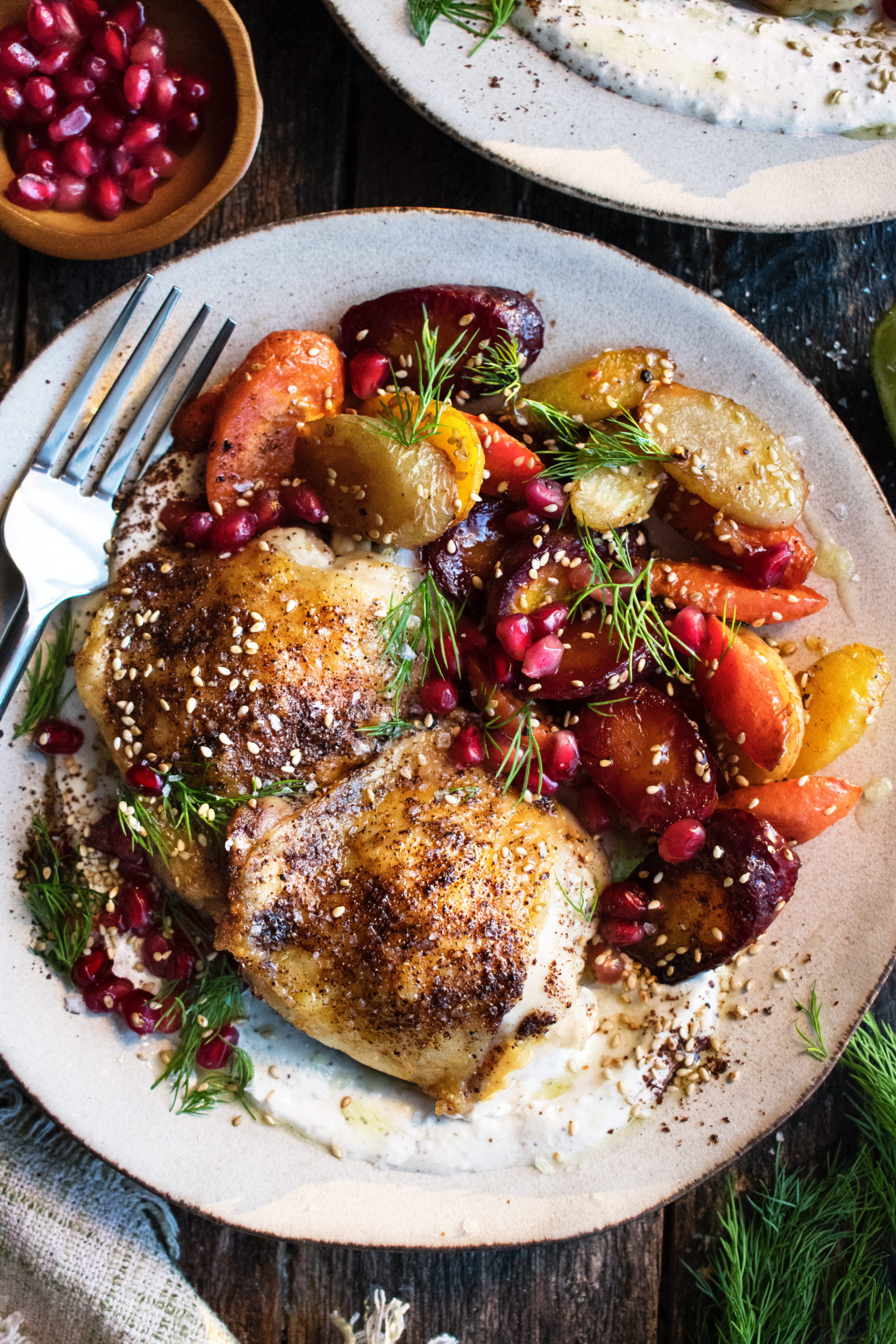 Spiced Chicken Thighs with garlicky tahini yogurt & pomegranate glazed carrots on a plate