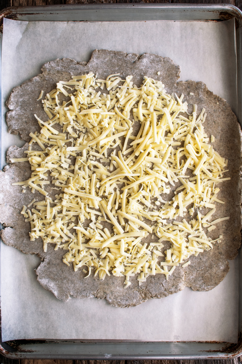 rolled out dough with cheddar cheese on top