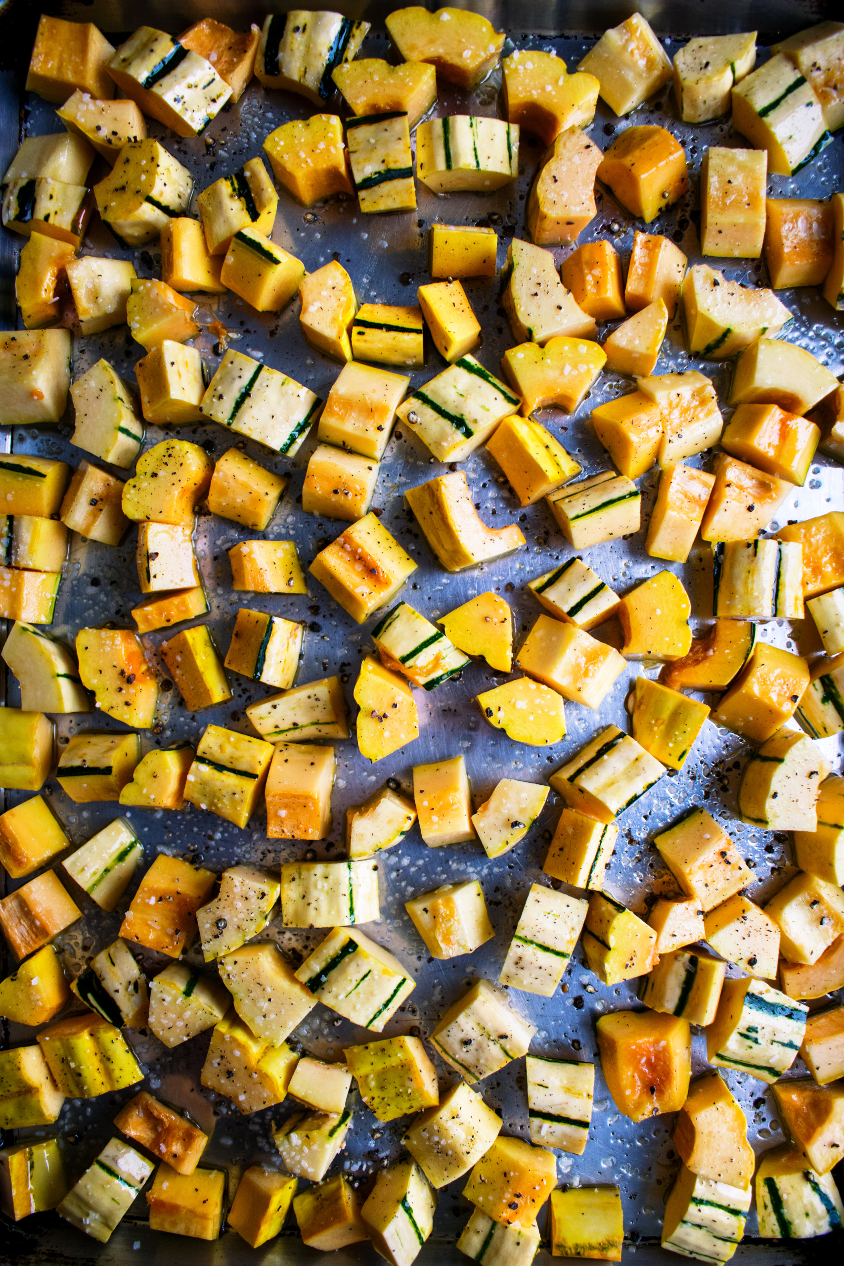 delicata squash cubed on a sheet pan before roasting